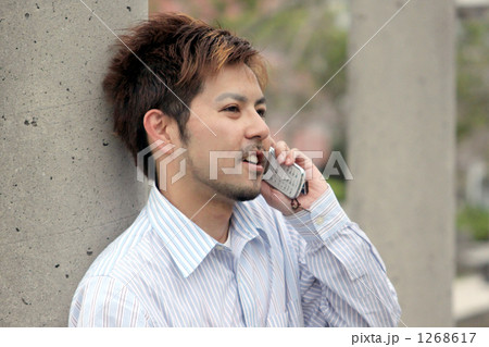 髭 茶髪 携帯電話 ワイシャツの写真素材