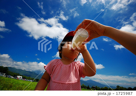 女の子 牛乳 一気飲み 青空の写真素材