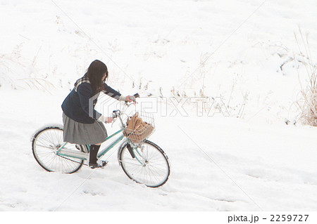 自転車 通学 女子高生 雪道の写真素材