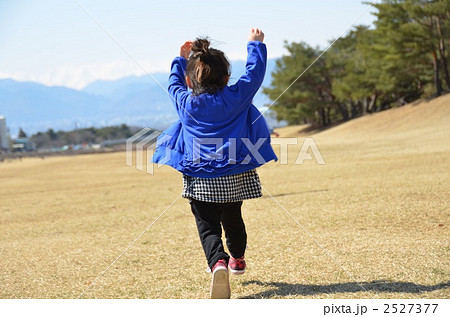 子供 女の子 走る 後姿の写真素材