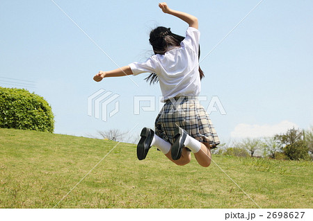 女の子 ジャンプ 飛ぶ 後姿 半袖の写真素材
