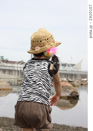 赤ちゃん 1人 後姿 石投げの写真素材