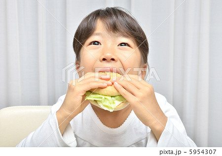 子供 食べる ハンバーガー かぶりつくの写真素材