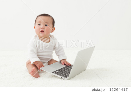 赤ちゃん ノートパソコン 興味 触るの写真素材