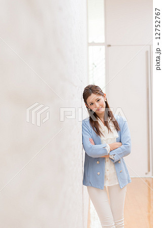 寄りかかる 女性 壁 人物の写真素材