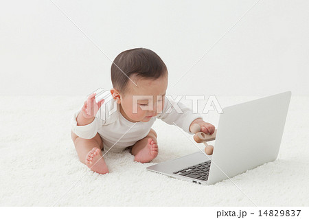 赤ちゃん ノートパソコン 興味 触るの写真素材
