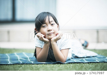 女性 頬杖 寝そべる 人物の写真素材