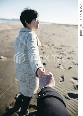 手を引く 浜辺 カップル デートの写真素材
