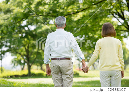 後姿 老夫婦 手を繋ぐ 散歩の写真素材