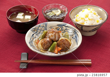 肉団子の甘酢あんかけととうもろこしご飯 味噌汁ともずく酢の写真素材