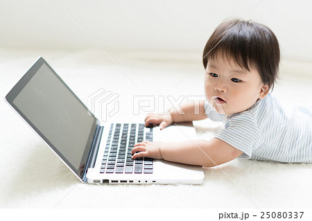 赤ちゃん ノートパソコン 興味 触るの写真素材