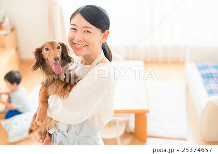 犬 抱っこ 主婦 ミニチュアダックスフンドの写真素材