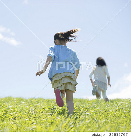 子供 女の子 走る 後姿の写真素材