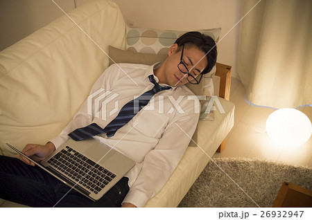 ビジネスマン ノートパソコン 疲労 ソファの写真素材