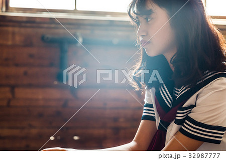 女子高生 陽射し 横向き 高校生の写真素材
