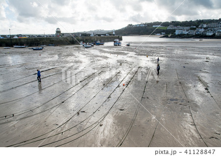 ロープ 潮が引いた 小舟 防波堤の写真素材