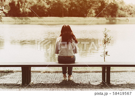 女の子 寂しい 後姿 悲しいの写真素材