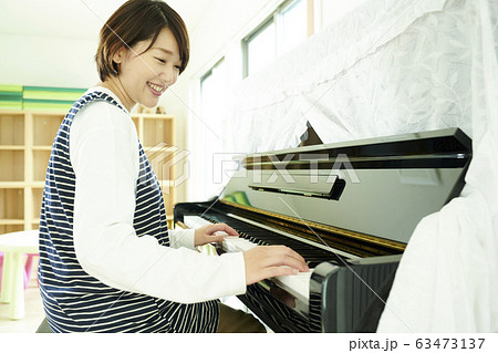 保育士 ピアノ 笑顔 女性の写真素材