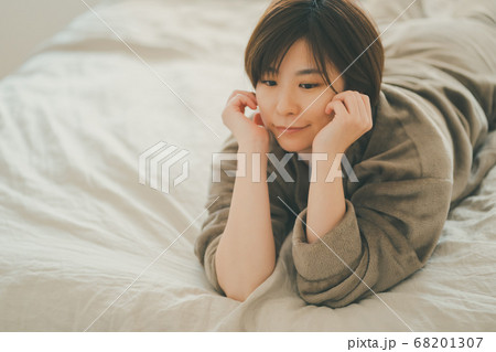 女性 頬杖 寝そべる 人物の写真素材