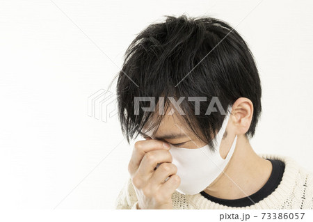 マスク姿の男性/頭痛で頭を抱える/具合が悪い独身男性/	