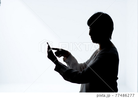 女性 携帯電話 シルエット 人物 女の写真素材