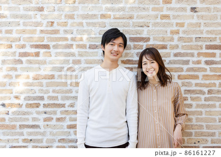 寄りかかる 女性 壁 人物の写真素材