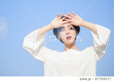 眩しい 女性 一人 手をかざすの写真素材